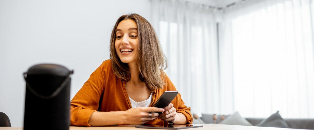 junge Frau spricht mit einem digitalen Assistenten