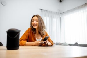 junge Frau spricht mit einem digitalen Assistenten